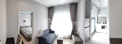 Modern apartment interior with cozy living room, bedroom, and kitchen featuring sleek design and ample natural light.