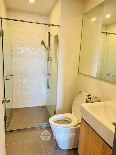 Modern bathroom with glass shower and sleek fixtures in a contemporary home.