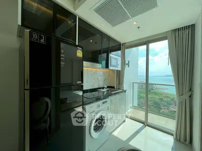 Modern kitchen with appliances and stunning ocean view from balcony.