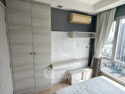 Modern bedroom with built-in wardrobe and city view window