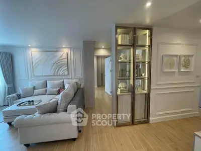 Elegant living room with plush sofas and decorative shelving in a modern apartment.
