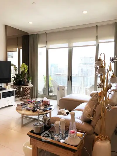 Spacious living room with large windows offering a stunning city view, modern decor, and cozy seating area.