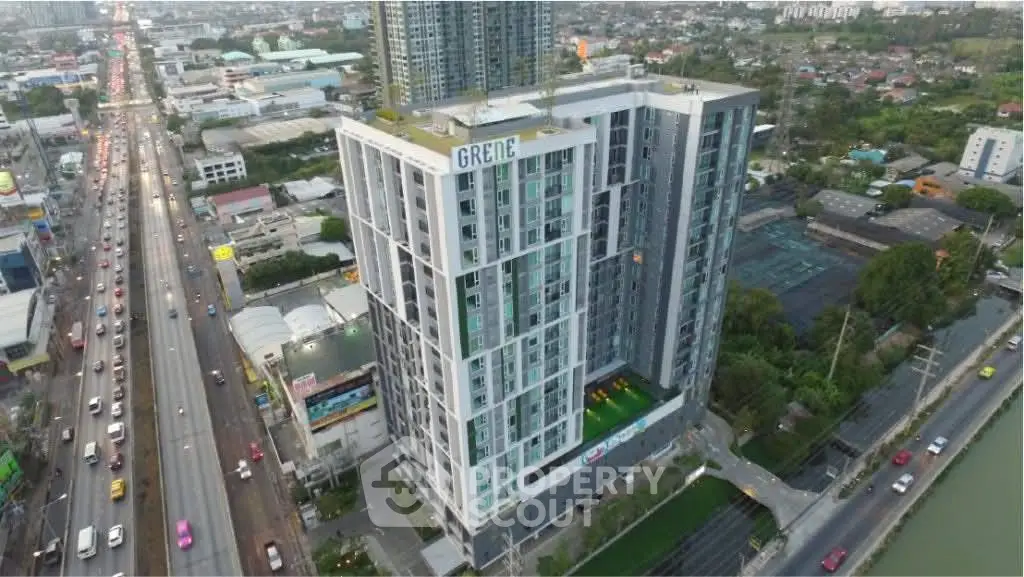 Aerial view of modern high-rise building with cityscape backdrop, showcasing urban living.