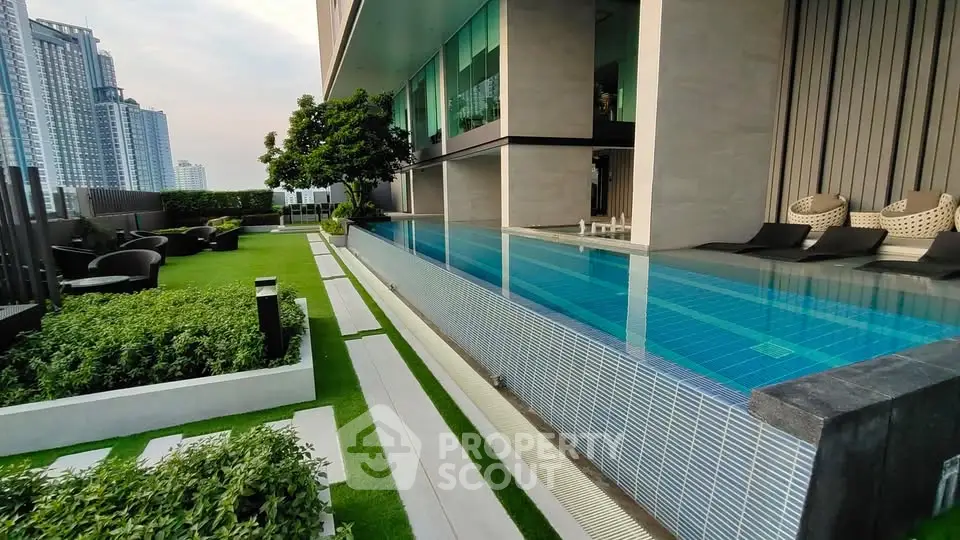 Luxurious rooftop pool with stunning city views and lush garden area in modern high-rise building.