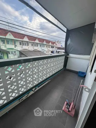 Charming balcony with privacy screen and neighborhood view, perfect for relaxation and outdoor enjoyment.