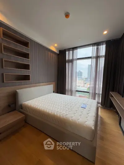 Spacious bedroom with modern design and city view, featuring a comfortable bed and stylish shelving.