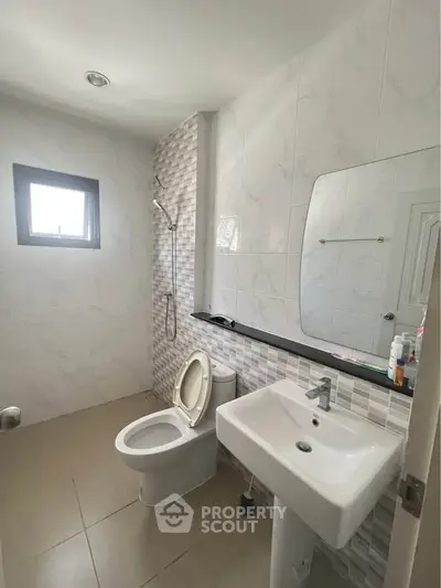Modern bathroom with sleek white fixtures and stylish tile design, perfect for contemporary living.