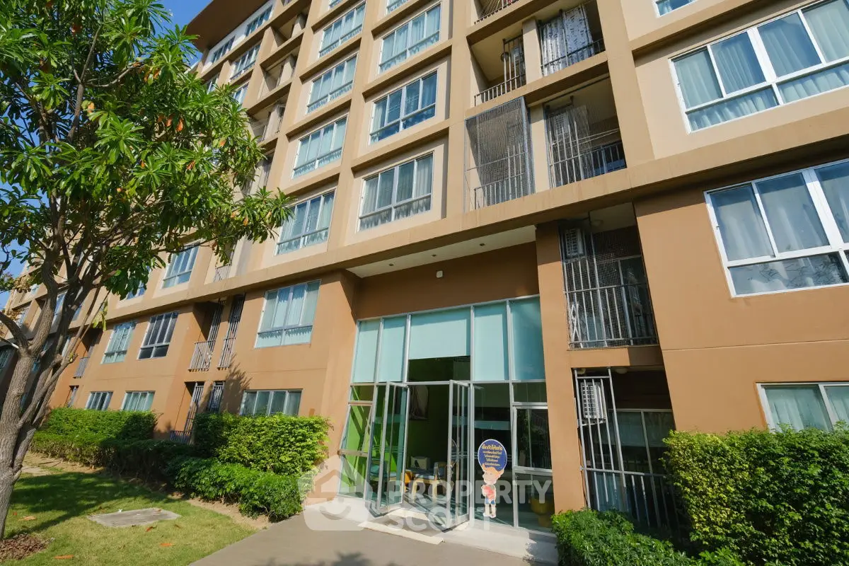 Modern apartment building exterior with lush greenery and large windows