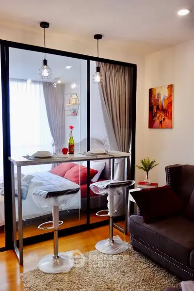 Stylish modern studio with glass partition, cozy seating, and elegant decor in urban setting.