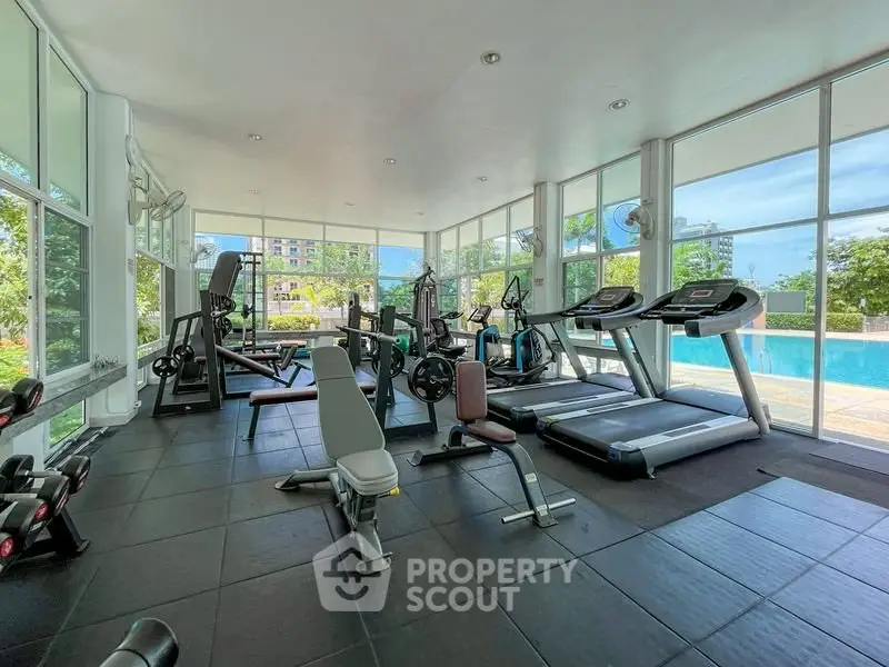 Modern gym with pool view in luxury residential complex