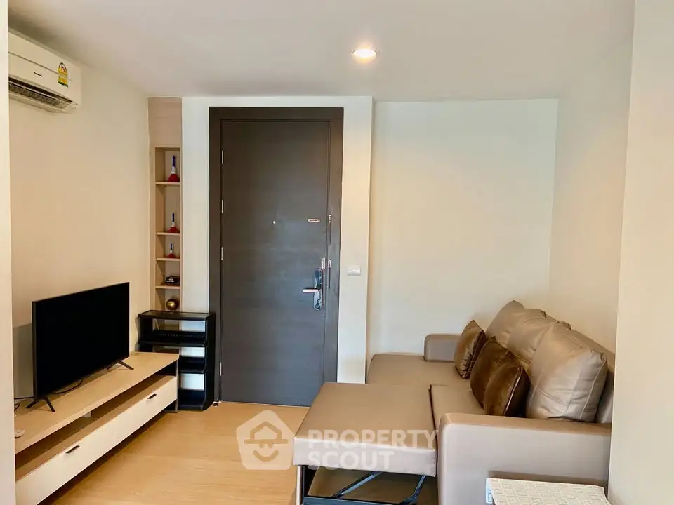 Cozy living room with modern furniture and TV, perfect for relaxation.