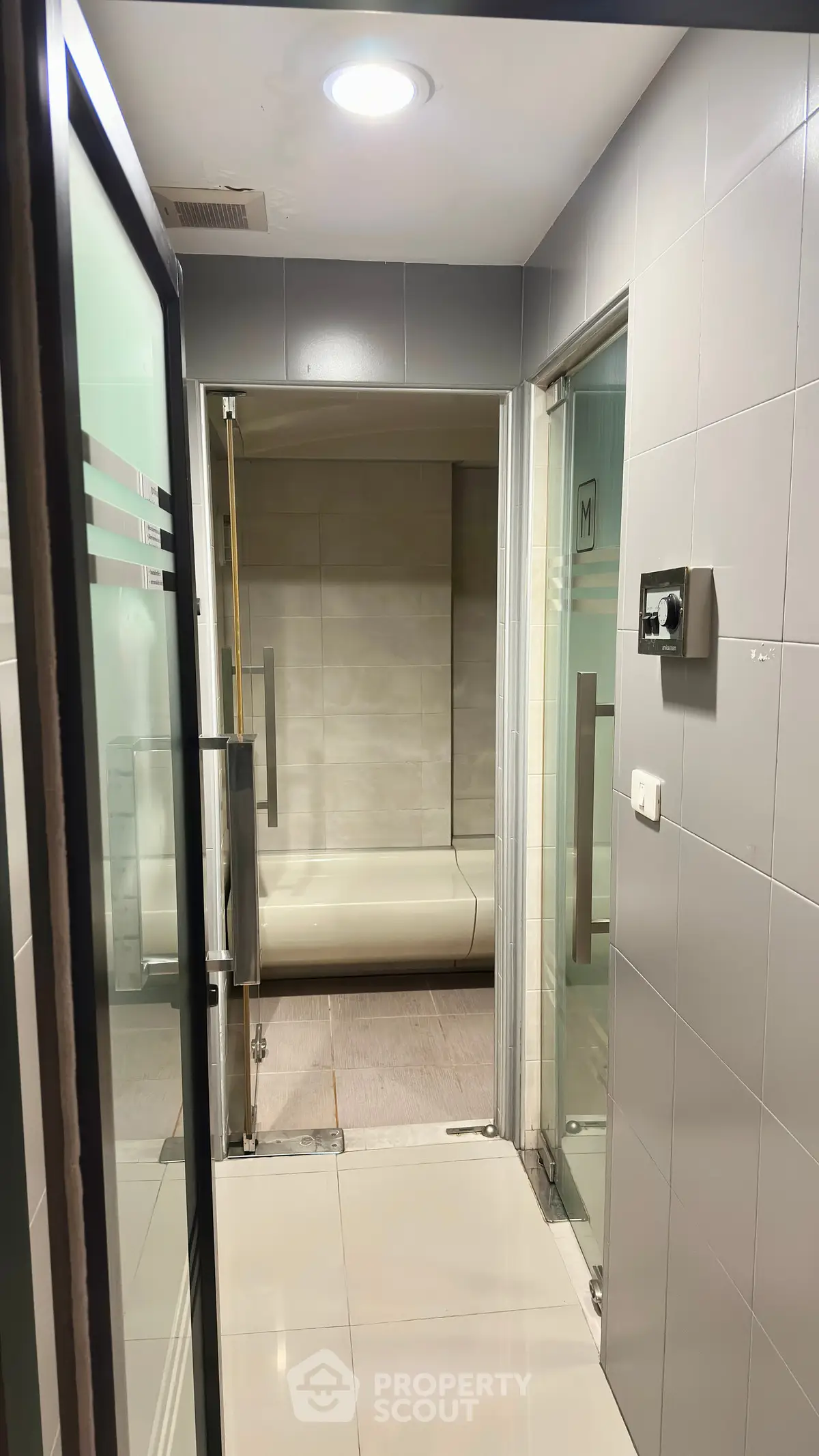 Modern bathroom with sleek design and glass doors, featuring a spacious shower area.