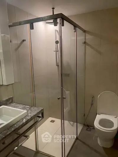 Modern bathroom with glass shower enclosure and sleek fixtures