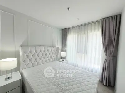 Elegant bedroom with plush headboard and soft lighting, featuring floor-to-ceiling curtains for a cozy ambiance.