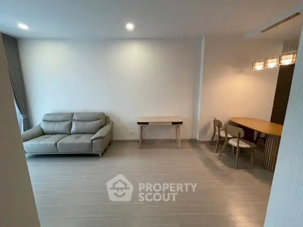 Modern living room with sleek furniture and elegant lighting in a spacious apartment.