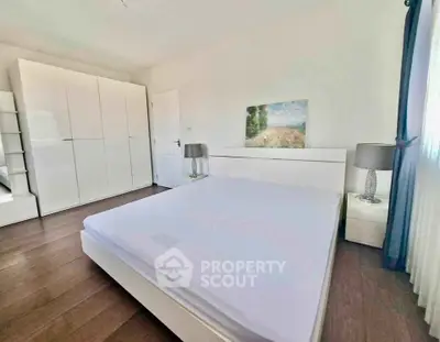Spacious bedroom with modern white furniture and natural light