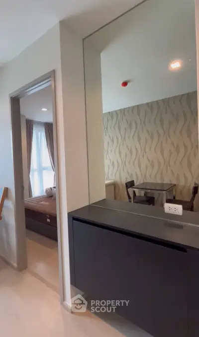 Modern apartment interior with stylish dining area and cozy bedroom view.