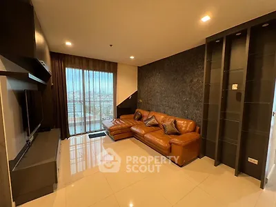 Spacious living room with leather sofa and city view, perfect for modern urban living.