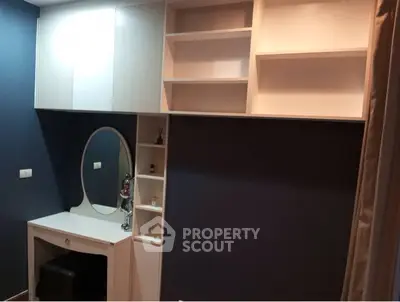 Modern bedroom with built-in shelves and stylish vanity area.