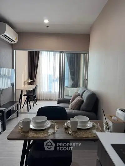 Modern living room with dining area and balcony view in a stylish apartment.