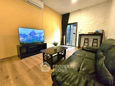 Cozy living room with leather sofa, flat-screen TV, and stylish decor