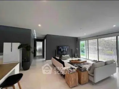 Spacious modern living room with sleek design and large windows offering natural light.