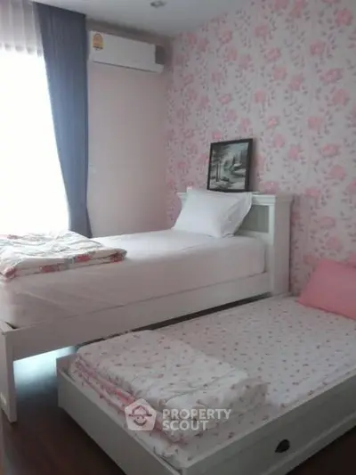 Charming bedroom with floral wallpaper and twin beds, perfect for a cozy and inviting atmosphere.