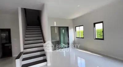Spacious modern living room with sleek staircase and large windows