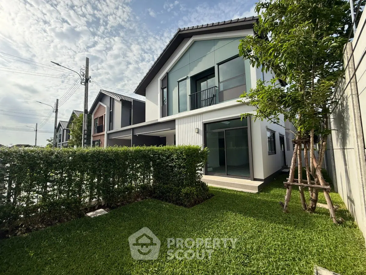 Modern two-story house with lush green lawn and contemporary design