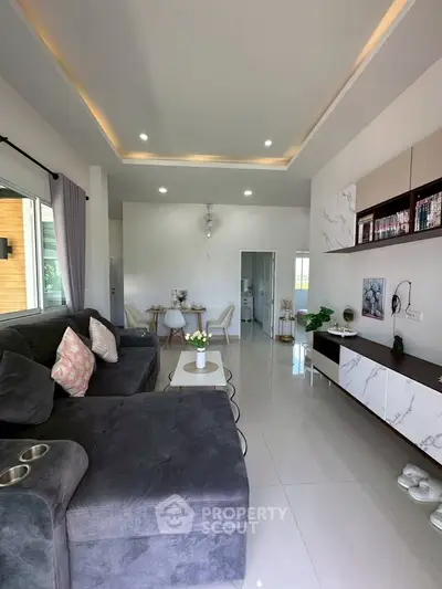 Modern living room with elegant decor and spacious layout, featuring a cozy sofa and stylish dining area.