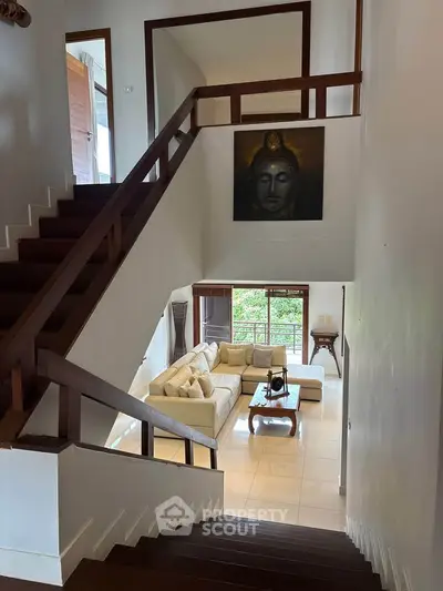 Spacious living room with elegant staircase and serene decor in a modern home