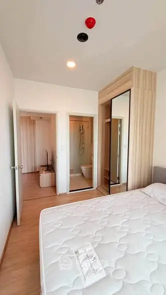 Modern bedroom with ensuite bathroom and stylish wardrobe in a contemporary apartment.