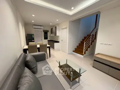 Modern living room with sleek furniture and open kitchen layout