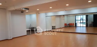 Spacious dance studio with mirrored walls and wooden flooring