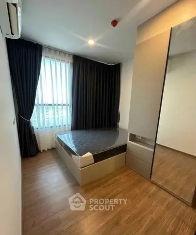 Modern bedroom with sleek design, large window, and stylish flooring.