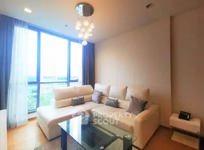 Modern living room with large windows and stylish furniture in a high-rise apartment.