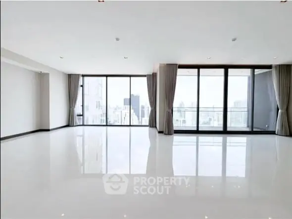 Spacious modern living room with large windows and city view, perfect for urban living.