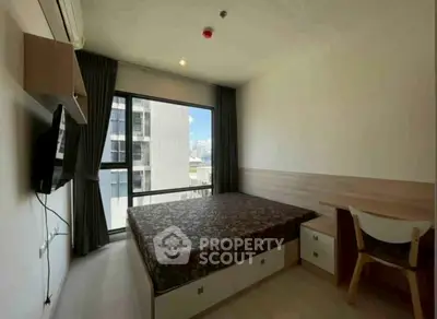 Modern bedroom with large window and city view, featuring a cozy bed and stylish furniture.