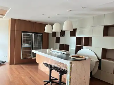 Modern kitchen with sleek design, featuring a marble island and stylish lighting.