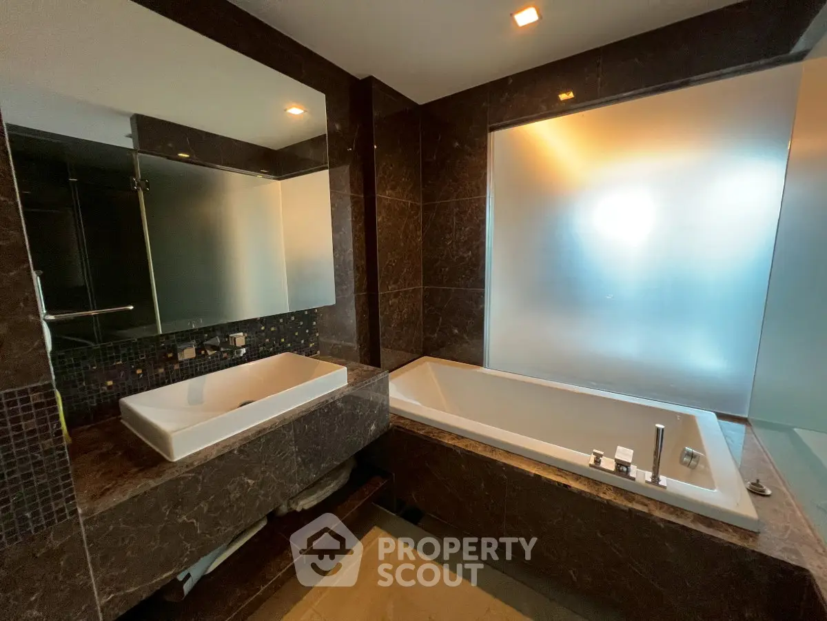 Luxurious bathroom with elegant dark marble and spacious bathtub
