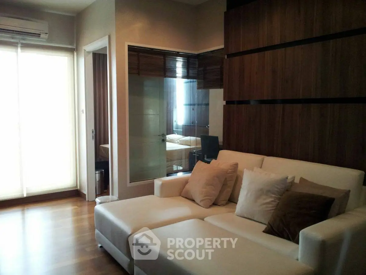 Modern living room with sleek design and cozy white sofa, featuring wooden accents and natural light.