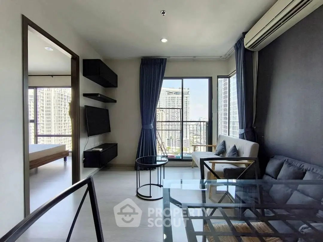 Modern living room with city view, featuring sleek furniture and large windows for natural light.