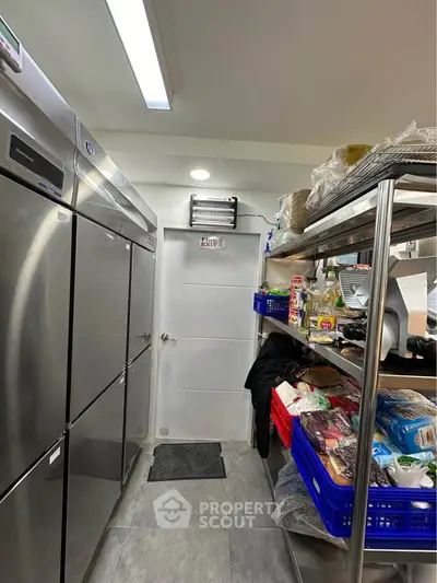 Spacious kitchen storage with stainless steel appliances and organized shelving.