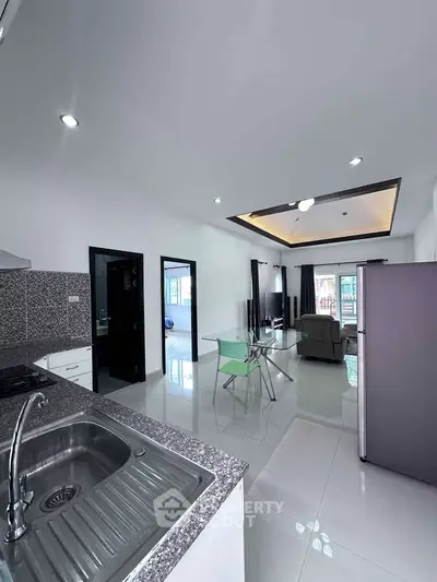 Modern open-plan kitchen and living area with sleek design and ample natural light.