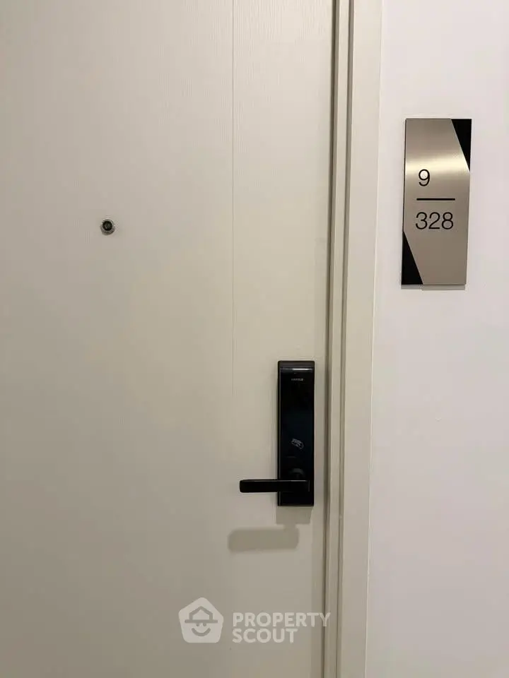 Modern apartment door with sleek handle and room number 328 on the ninth floor.