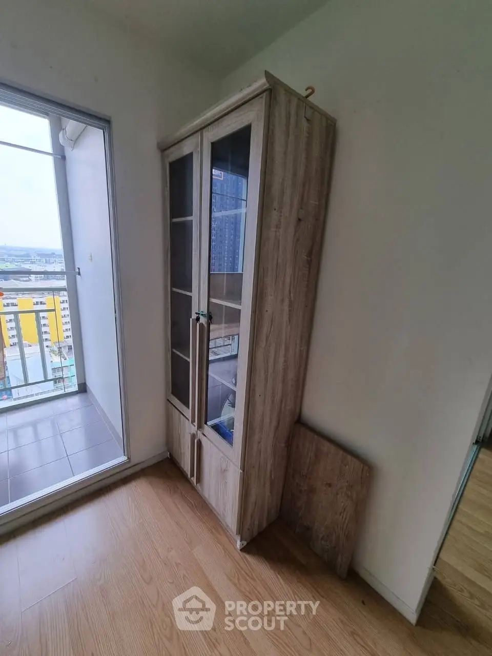 Modern apartment with wooden flooring and glass cabinet near balcony