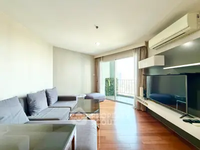 Spacious modern living room with large TV and balcony access