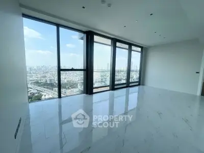 Spacious modern living room with floor-to-ceiling windows offering stunning city views.