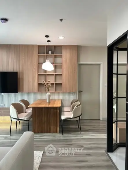 Modern dining area with wooden accents and stylish lighting in open-plan living space.