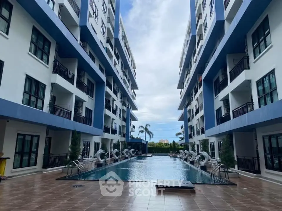 Modern apartment complex with central swimming pool and spacious balconies.